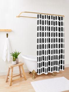 a white bath tub sitting next to a wooden stool in a bathroom under a shower curtain