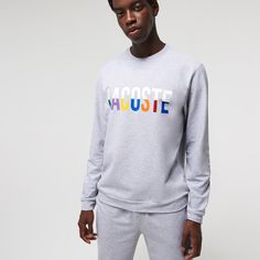 Adorned with oversized multicolor brand lettering, this solid lounge sweatshirt is perfect for kicking back. Crafted in soft cotton blend fleece, it has a classic straight cut and a ribbed crew neck. Get the total look when you pair it with the coordinating pants. Brand Lettering, Lacoste Men, Kick Backs, Total Look, Cotton Fleece, 2024 Collection, Straight Cut, Grey Sweater, Stretch Cotton