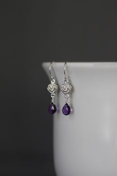 "Sweet faceted Purple Amethyst teardrops are carefully wire wrapped with silver wire onto Bali Silver rose flower links. These dangle from balled silver earwires. Wear these lightweight petite everyday to work or with your favorite jeans. Perfect for girls and women of any age. Bali Silver rose link: 7x12mm Amethyst teardrops: 5x7mm Total length of earrings: 1 1/4\" All silver is sterling. As the owner, maker, designer, and curator of this shop, I take great pride in providing you with jewelry t Elegant Purple Sterling Silver Flower Earrings, Sterling Silver Wire Wrapped Crystal Earrings, Sterling Silver Briolette Teardrop Earrings For Gift, Hypoallergenic Sterling Silver Teardrop Flower Earrings, Hypoallergenic Teardrop Flower Earrings In Sterling Silver, Elegant Purple Teardrop Flower Earrings, Anniversary Teardrop Flower Earrings, Elegant Adjustable Wire Wrapped Teardrop Earrings, Nickel-free Sterling Silver Teardrop Flower Earrings