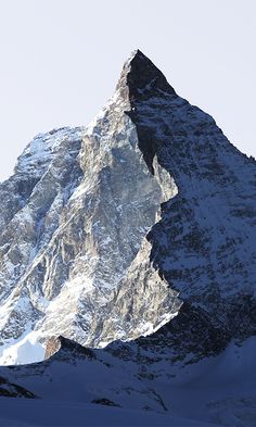 a snowboarder is standing on the top of a mountain