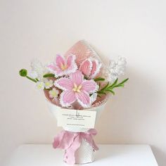 a bouquet of pink and white flowers sitting on top of a table