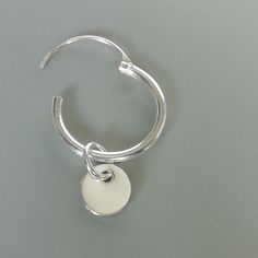 A PAIR of sterling silver hoops. Comes with a detachable tiny and delicate round disc charm. The charm is multipurpose and can be used with a neck or bracelet chain too. Dimension: Hoop- 12x1.2 mm Charm- 5 mm Drop length- 17 mm Price listed is for ONE PAIR These are made of 925 hypoallergenic sterling silver. Most of my pieces come with a 925 stamp. Can be packaged in a gift box. I can include a personal message from you if needed You are welcome to contact me at... bhavnakwintra1956@gmail.com F Minimalist Nickel-free Small Hoop Huggie Earrings, Silver Minimalist Huggie Dangle Earrings, Minimalist Silver Round Huggie Earrings, Minimalist Silver Dangle Huggie Earrings, Minimalist White Gold Huggie Earrings, Minimalist Metal Round Huggie Earrings, Minimalist Round Metal Huggie Earrings, Minimalist Huggie Dangle Earrings With Charms, Silver Minimalist Single Hoop Earring