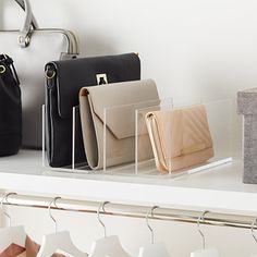 several purses are lined up on a shelf