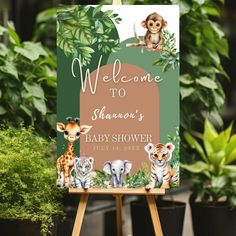 a welcome sign for a baby shower with animals on it and plants in the background