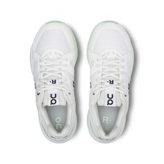 a pair of white sneakers with green accents