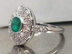 Vintage natural emerald in 14k white gold ring circ 1940's center natural green emerald in round shape weight 0.92ct SIZE 5.8mm side set natural diamonds weight 0.50ct H-SI1 lively,sparkly stone.clean. Ring size 6.5 This tremendous old vintage ring is in a very good condition. Appraisal available Retail value $4,750 net Vintage Green Emerald Ring Gia Certified, Gia Certified Green Diamond Ring In Vintage Style, Art Deco Round Emerald Ring With Center Stone, Classic Round Emerald Ring With Halo Design, Art Deco Emerald Ring In Platinum, Art Deco Platinum Emerald Ring, Classic Round Emerald Ring With Halo Setting, Art Deco Round Green Emerald Ring, Classic Green Diamond Round Ring