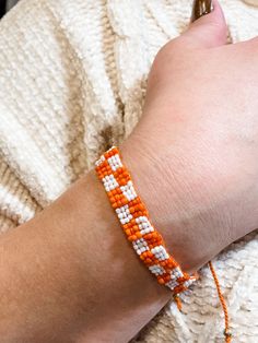 Beaded Orange and White Checkerboard Adjustable Bracelet Orange Seed Bead Bracelet, Handmade Orange Casual Friendship Bracelet, Casual Handmade Orange Friendship Bracelets, Casual Handmade Orange Friendship Bracelet, Trendy Orange Friendship Bracelets As Gift, Trendy Orange Friendship Bracelets Gift, Trendy Orange Friendship Bracelet Gift, Casual Orange Braided Bracelets For Friendship, Casual Orange Braided Bracelet For Friendship