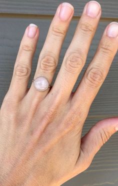 A beautiful round pink rose quartz sits in sterling silver with a handmade ring band from sterling silver half dome wire. Choose from either a simple setting or a more floral scallop setting. The rose quartz cabochon is 11mm in size. Rose quartz is a stone that promotes healing, love, and attraction. It can draw love to the the wearer, help heal from heartbreak, and help sustain feelings of love and romance. Made to order, stones vary with slight differences in color, lines, etc. Adjustable Minimalist Dome Ring, Wire Wrapped Rose Gold Rings, Adjustable Rose Quartz Rose Gold Ring, Adjustable Round Rose Quartz Jewelry, Adjustable Round Pink Jewelry, Adjustable Pink Round Jewelry, Pink Adjustable Jewelry, Delicate Sterling Silver Pearl Ring, Minimalist Pink Crystal Ring As Gift