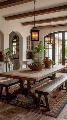 a dining room table with benches and potted plants in the center is surrounded by windows