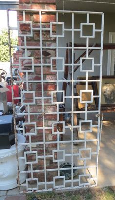 a brick wall with a white trellis on it