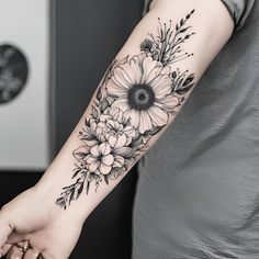 a woman's arm with flowers and leaves on it