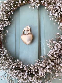 a blue door with a wreath on it and a heart shaped object in the middle