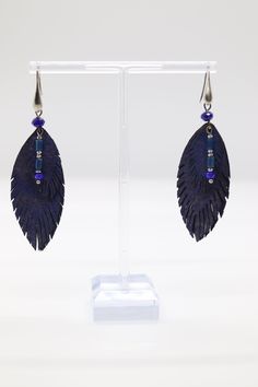 Blue feather earrings are delicate accessories crafted with vibrant blue feathers, elegantly dangling from a gold hook, adding a touch of nature-inspired beauty to any outfit. Their graceful design complements both casual and formal styles, making them a versatile and eye-catching addition to any jewelry collection. Elegant Blue Feather Earrings, Blue Feather Dangle Earrings, Adjustable Blue Feather Earrings, Blue Feather Earrings As Gift, Blue Feather Earrings Gift, Blue Feather Earrings For Gift, Blue Feathers, Blue Feather, Green Earrings