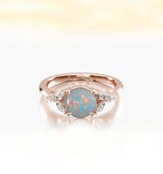 an opal and diamond ring on a white background