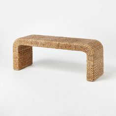 a wicker bench sitting on top of a white floor