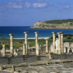 an ancient city by the ocean with many columns