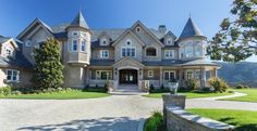 a large house with lots of windows on the front and side of it's driveway