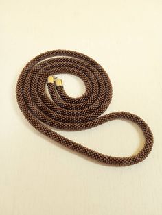 a long brown rope on a white surface