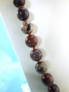 "Vintage 1980's Hand Knotted Necklace, Semi-Precious Brecciated Jasper Gemstone 10mm smooth polished round beads, 32\" opera length. This necklace has some weight to it. PLEASE SEE ALL PHOTOS FOR MORE DETAILS AND CLOSE UPS.  Jasper is a variety of quartz that may contain up to 20 percent foreign materials or inclusions, including organic material and mineral oxides, which determine the color, pattern and appearance of the stone. Brecciated jasper contains hematite, an iron compound, which gives it both its red tones and the dark bands. It is primarily deep red--veined or patterned with brown, black and beige--and sometimes has clear crystal inclusions." Jasper Beaded Necklaces With Polished Round Beads, Brown Jasper Necklace With Gemstone Beads, Polished Jasper Beaded Necklaces, Jasper Polished Round Beaded Necklaces, Brown Jasper Gemstone Bead Necklace, Hand-strung Jasper Beaded Necklaces With Round Beads, Unique Multicolor Jasper Necklaces, Hand-strung Jasper Bead Necklaces, Unique Brown Jasper Necklace