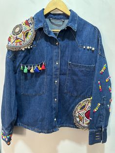 Presenting beautiful boho denim jacket banjara work. This is premium quality denim jacket detailed with hand work,patch work,beads work. The jacket you will receive will be the exect one in the photos. For bulk/ wholesale orders kindly message us. If you have any queries,feel free to ask. PLEASE MENTION YOUR CONTACT NUMBER AT THE TIME OF PURCHASE ITS REQUIRED FOR FAST AND EASY SHIPPING PURPOSE. Navratri Denim Jacket, Navratri Jeans, Navratri Jacket, Boho Denim Jacket, Denim Jacket With Patches, Diy Hoodie, Denim Jacket Embroidery, Jacket Patchwork, Jacket Embroidery