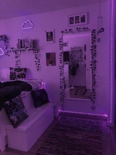 a bed room with a couch a mirror and purple lights on the wall above it