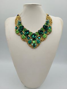 Each piece of our statement necklaces is handmade and one of a kind made in Italy. Our creations is made of high quality materials such as crystals and rhinestones. Each embroidered material is carefully hand sewn. Very glamorous and stylish. Perfect gift to someone you like. Materials Strass stone and Rhinestone in Emerald and Peridot color in different dimension.  Black satin fabric backing. Aluminium chain with lobster closure. Measurements Weight approximate 200 grams. Chain lenght 25 cm - 9.84 in Circumference approximate 63 cm - 24.80 in Feel free to contact us if you have any question. Thank you so much for looking at our shop and our articles each of them, single piece. Unique Crystal Necklace For Gift, Unique Necklaces With Jewels For Parties, Unique Jeweled Necklace For Party, Jeweled Bib Necklace As Costume Jewelry Gift, Jeweled Costume Jewelry Bib Necklace As Gift, Costume Jewelry Bib Necklace With Jewels For Gifts, Costume Jewelry Bib Necklace With Jewels As Gift, Green Crystal Beaded Necklaces As Gift, Handmade Pendant Necklace For Party