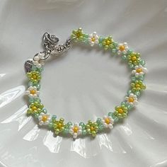 "Handmade Beaded Bracelet 🍵 ✿ Made with glass seed beads and metal accents ✿ Matcha green, milky white, yellow, and sea foam green ✿ The bracelet has 1.5\" of extension chain" Green Beaded Bracelet With Spacer Beads For Friendship, Green Beaded Bracelet For Gift, Green Beaded Chain Bracelets As A Gift, Green Beaded Chain Bracelet As Gift, Green Beaded Chain Bracelet For Gift, Green Bracelets With Tiny Beads For Summer, Green Beaded Chain Bracelets For Jewelry Making, Green Beaded Chain Bracelet For Jewelry Making, Hand-strung Green Beaded Bracelets For Summer