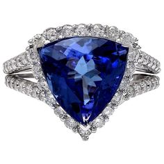 Introducing our stunning 7.07 Carat Tanzanite 14K Solid White Gold Diamond Ring. Crafted from luxurious 14K White Gold, this ring features a captivating trillion-cut Tanzanite weighing 5.41 carats, with dimensions of 11.00x11.00 mm, showcasing its mesmerizing hues. Adorning the sides are sparkling Diamonds weighing 1.66 carats in total, with a color range of F-G and clarity between VS2-SI1, adding brilliance and elegance. With a total metal weight of 4.9 grams and a face measurement of 14.50x14. Gia Certified Trillion Cut Diamond Ring For Formal Occasions, Gia Certified Trillion Cut Diamond Ring For Formal Events, Elegant Gia Certified Trillion Cut Ring, Formal Trillion Cut Ring With Halo Setting, Trillion Cut Halo Setting Ring For Formal Occasions, Trillion Cut Halo Ring For Formal Occasions, Gia Certified Trillion Cut Formal Rings, Formal Gia Certified Trillion Cut Ring, Formal Tanzanite Trillion Cut Ring