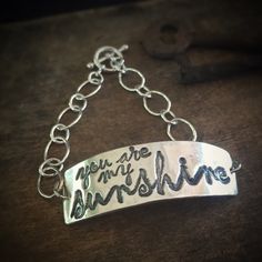 "\"You Are My Sunshine\". Are you singing already? This bracelet is a little piece of happy. This bracelet is lovingly made from recycled fine silver, and 2 sets of sterling silver chain. It is finished with a toggle clasp. The silver artwork charm is approximately 1 3/4 inches across and 1/2 inch wide. If you require a bracelet size other than a standard 7 inches, simply leave me a note during checkout with your desired size. Not familiar with fine silver? Here are the facts: Fine silver has a Personalized Adjustable Sterling Silver Bracelet, Adjustable Sterling Silver Meaningful Jewelry, Customized Inspirational Bracelets For Gifts, Customized Inspirational Bracelets For Gift, Meaningful Engraved Bracelet Jewelry, Inspirational Engraved Name Bracelet, Personalized Sterling Silver Meaningful Bracelets, Engraved Sterling Silver Bracelets For Promise, Customized Meaningful Jewelry Bracelet