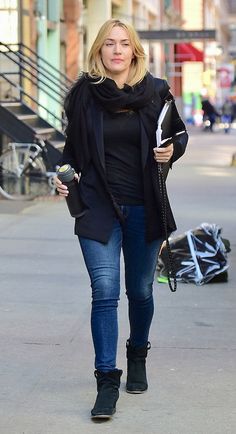 a woman is walking down the street with her cell phone