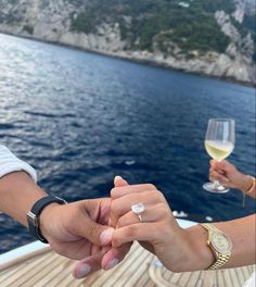 two people holding hands while on a boat