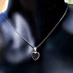 Hearts symbolize love and commitment, giving this delicate, brightly polished pendant necklace added meaning along with pure style. A black cubic zirconia inlay is set in the middle framed by a heart-shaped halo beautifully centered on a shiny black cable chain made of sterling silver. This lovely necklace is made of oxidized silver and the heart has 2 sides, one with black zircons and one with white zircons, so you basically have 2 necklaces for the price of one. DETAILS - 925 Sterling Silver Gift Silver Necklace With Black Diamonds, Black Enamel Necklace For Anniversary, Black Necklaces For Anniversary On Valentine's Day, Black Necklace For Anniversary On Valentine's Day, Valentine's Day Black Necklace For Anniversary, Black Heart-shaped Jewelry For Anniversary, Black Pendant Necklaces For Anniversary, Black Sterling Silver Double Heart Jewelry, Black Cubic Zirconia Pendant Jewelry