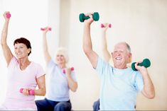 an older man and woman doing exercises with dumbbells