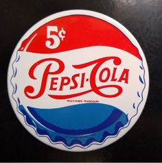 a red, white and blue pepsi cola sticker sitting on top of a table