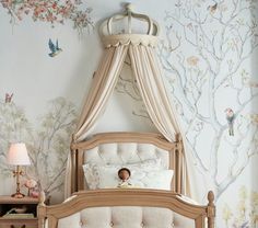 a child's bedroom with a canopy bed and wallpapered trees on the walls