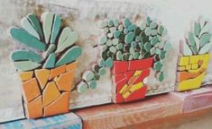 three pots with plants painted on them sitting on a window sill