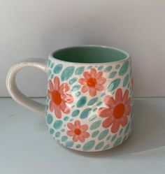 a ceramic mug with flowers painted on it