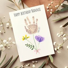 a birthday card with an image of a hand and flowers