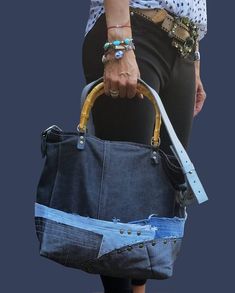 a woman carrying a blue bag with holes in it's sides and straps on the handles