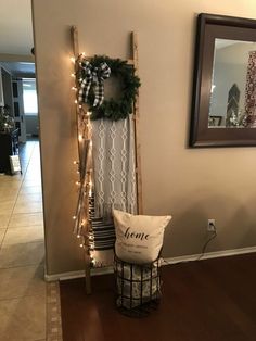 a wooden ladder decorated with christmas lights and a wreath on the wall next to it