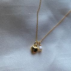 The sweetest necklace you could wear. The cutest gold heart charm in paired with a small little rice pearl to add a classy and dainty touch. This necklace is 17 inches in length. This necklace is made out of gold filled materials, so it is safe to wear in water, but should stay away from chemicals like in soaps, lotions, and perfumes. Sweet Necklace, Shoe Charms, Gold Heart, Heart Of Gold, In Water, Heart Charm, Shop Necklaces, The Cutest, Chemicals