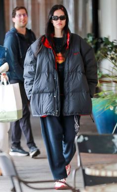 a woman walking down the street carrying shopping bags