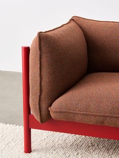 a brown chair sitting on top of a rug next to a white wall and floor