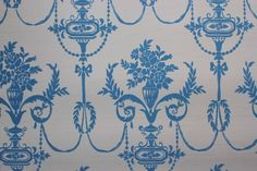 a blue and white wallpaper with floral designs