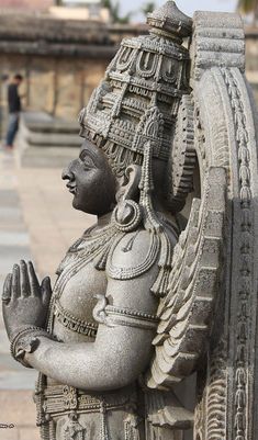 a statue of a woman holding her hands in one hand and wearing a headdress