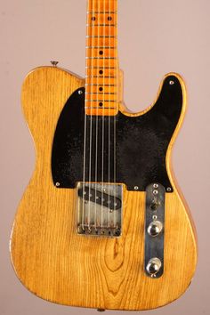 an electric guitar hanging on the wall with its neck missing from it's body