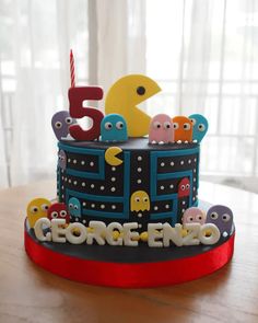 a birthday cake with pacman figures on top and candles in the shape of numbers