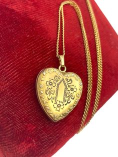 Description: A lovely vintage gold filled and etched heart shaped locket made by Pittman & Keeler Company on a 14K gold filled chain. This floral locket necklace features an etched front design that is made up of a central pentagon shape surrounded by flowers and leaves.  The edges along the front of the heart have a raised flower and leaf design as well. The back side of this locket is plain with no design.   NOTE: This locket is hallmarked P&K on the inside frame. This stands for the Pittman & Sweetheart Jewelry, American Queen, Pentagon Shape, Vintage Lockets, Heart Locket, Jewelry Companies, Locket Necklace, Front Design, Floral Flowers