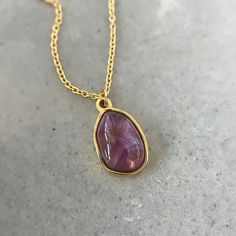 This beautiful piece features a stunning purple amethyst crystal, which is known for its metaphysical properties. The gemstone necklace comes on a delicate 18k chain, making it perfect for layering or wearing alone.

 	Chain: 18K Gold Plated
 	
Closure: Lobster claw
 	
Style: Boho & Minimalist
 	The model is pictured wearing an 18"
 	Collection: Amethyst Necklace Amethyst Crystal Pendant Necklace With Stones, Elegant Amethyst Crystal Necklace, Amethyst Necklace Pendant Gold, Elegant Gold Amethyst Crystal Necklaces, Gold Amethyst Pendant Crystal Necklace, Amethyst Pendant Necklace, Amethyst Necklace Pendant, Chain Making, Amethyst Pendant