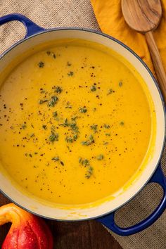 a blue pot filled with soup next to an apple